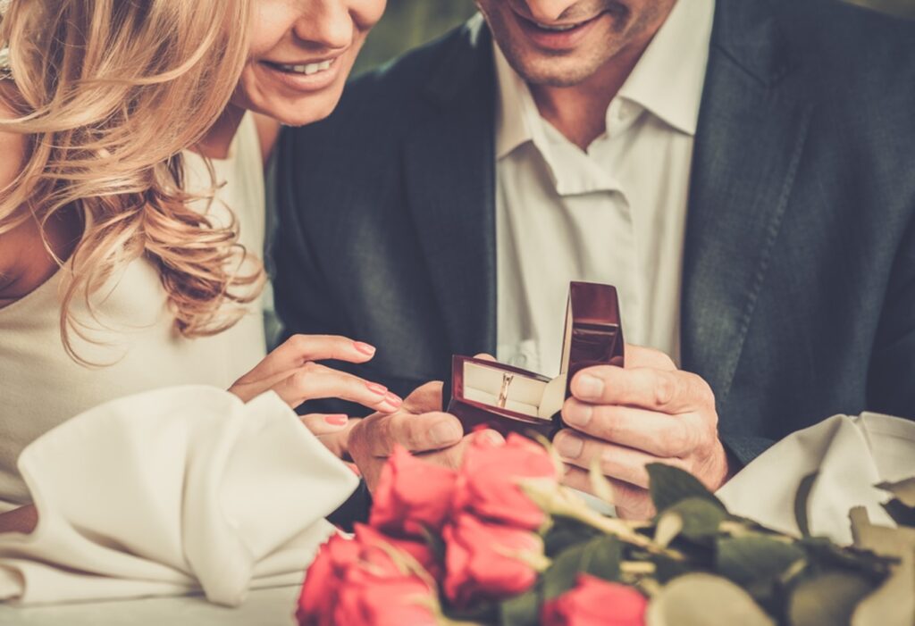 Close up of a handsome young man presenting an engagement ring to a beautiful young woman
